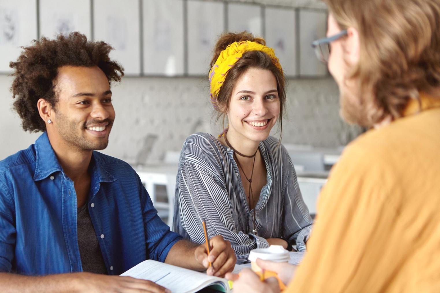 Persona che analizza testi letterari con annotazioni e note sparse sul tavolo